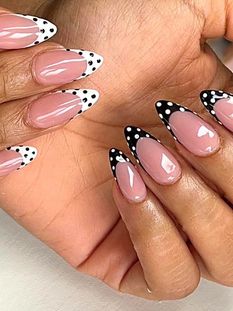 Nude nails with black and white dotted tips and heart accents